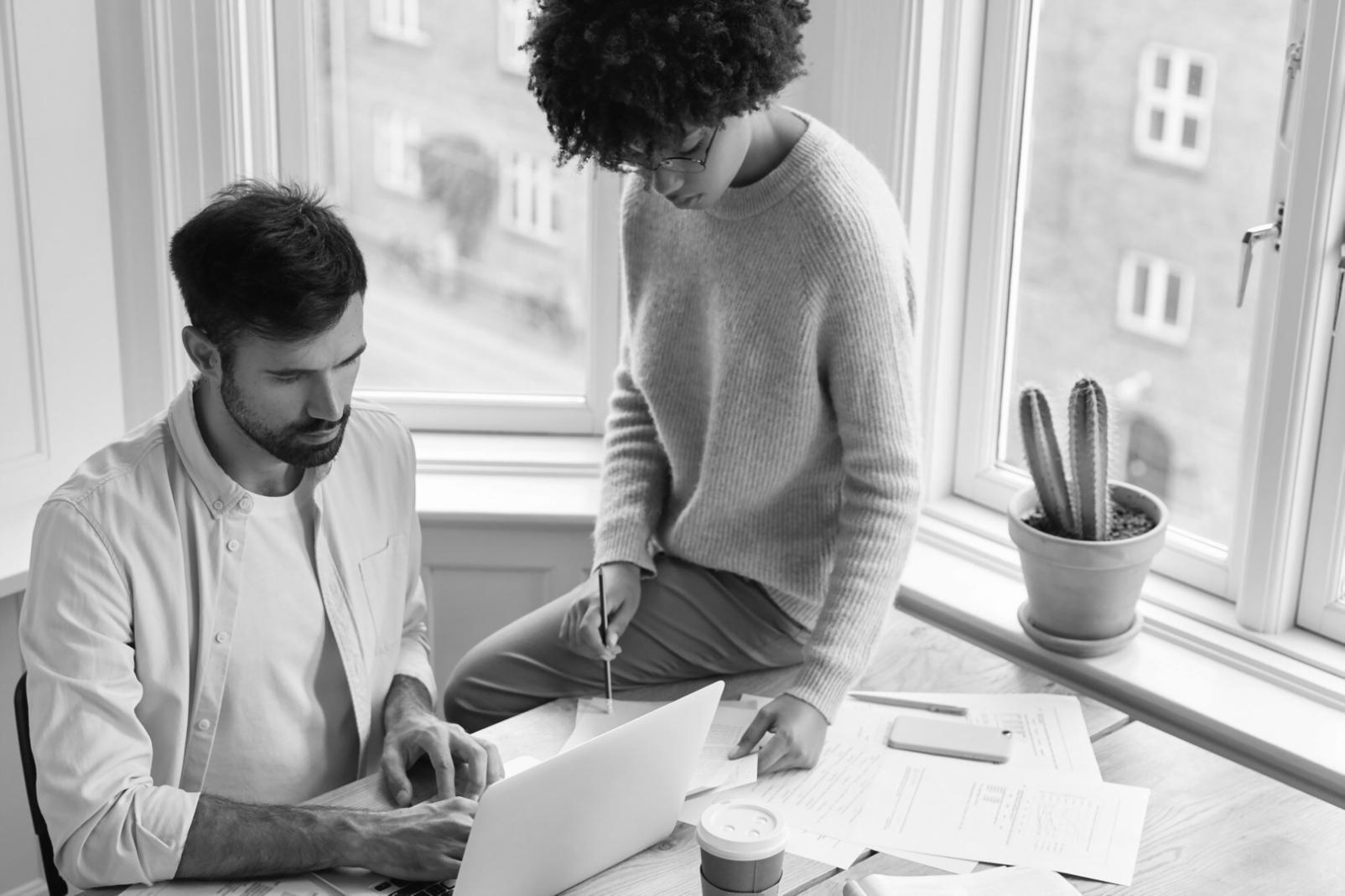 Étudiant travaillant sur son budget avec un ordinateur et des documents financiers